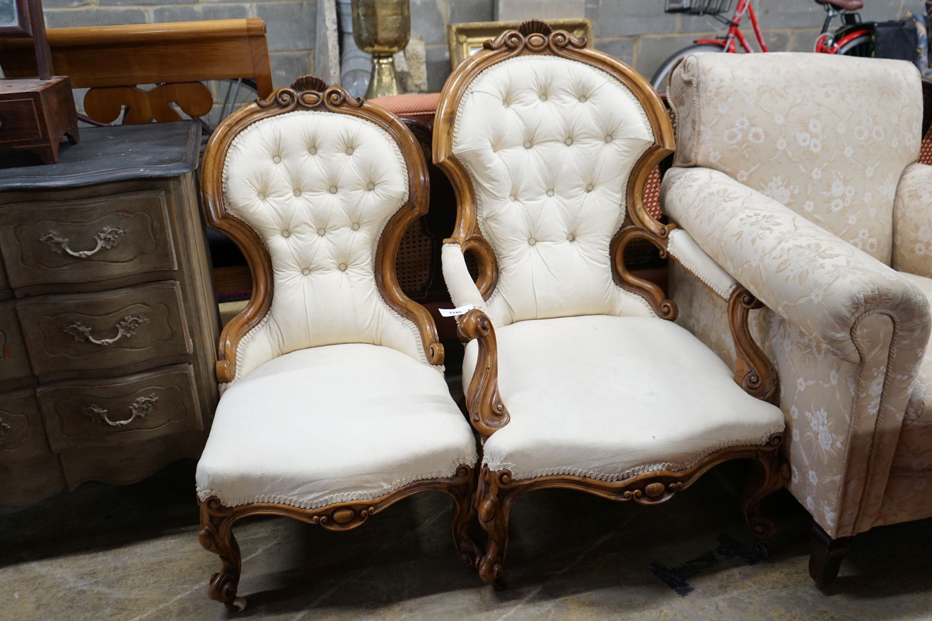 A pair of Victorian carved walnut chairs, one with arms